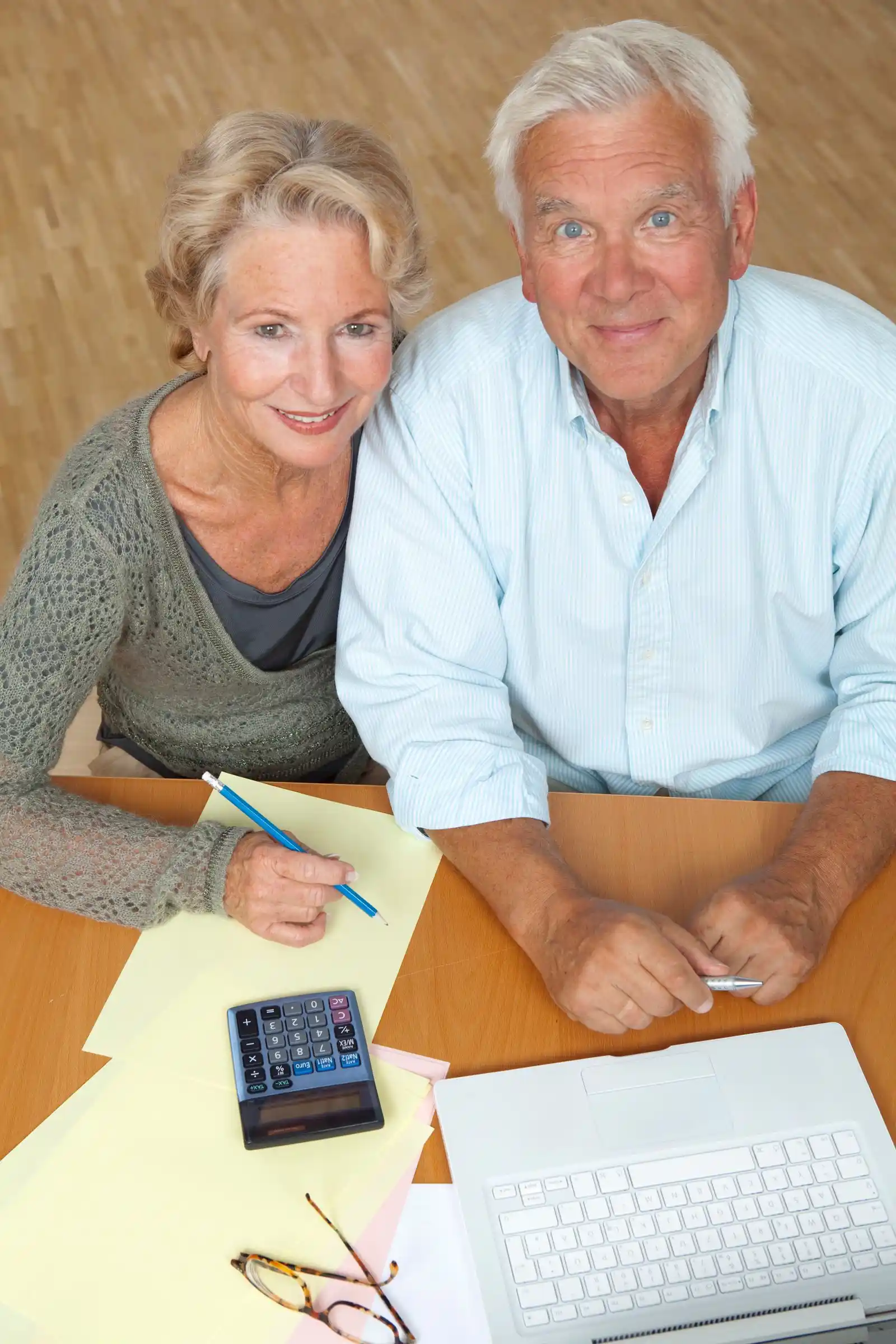 Senior couple using a laptop and a calculator to plan their finances